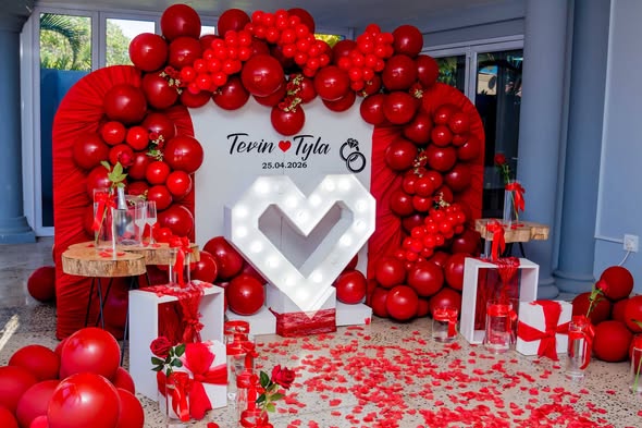 Red balloon arch and marquee heart at an engagement proposal